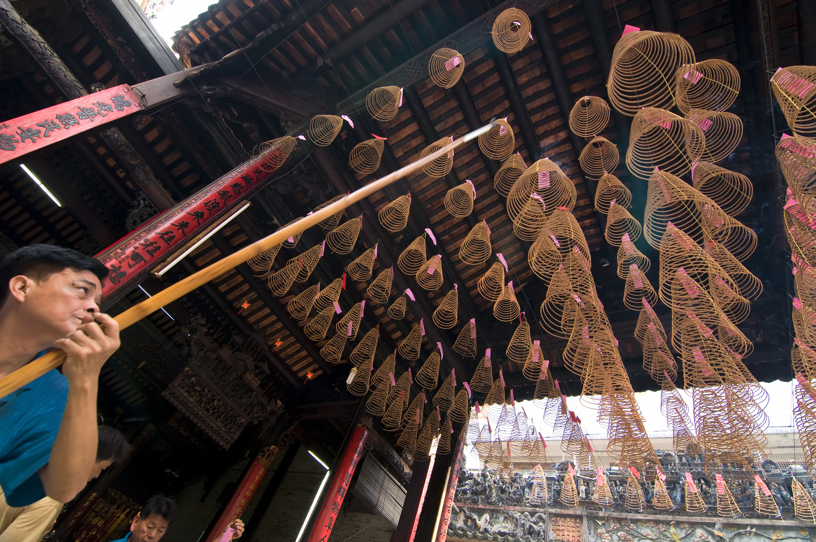 Ho Chi Minh, Vietnam - March 8, 2015: This gorgeous 19th-century temple is dedicated to the goddess Thien Hau, and always attracts a mix of worshippers and visitors who mingle beneath the large coils of incense suspended overhead. It is believed that Thien Hau can travel over the oceans on a mat and ride the clouds to save people in trouble on the high seas.